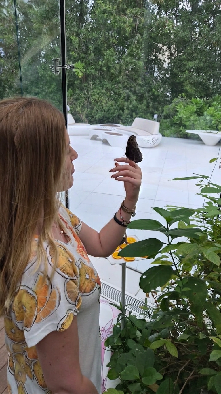 Mulher contemplando uma borboleta pousada em sua mão